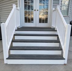 a white door and some steps in front of a house