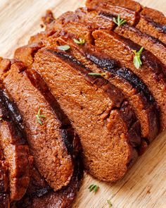 sliced up meat sitting on top of a wooden cutting board