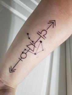 a woman's arm with an arrow and stars tattoo on the left side of her leg