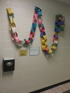 three pieces of colored paper are hanging on the wall next to each other in a hallway