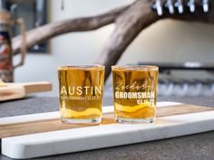 two shot glasses sitting on top of a cutting board