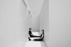 two people sitting on the floor in an empty room