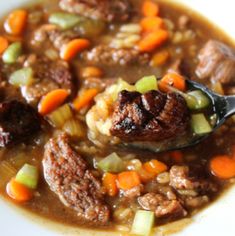 a white bowl filled with meat and vegetables