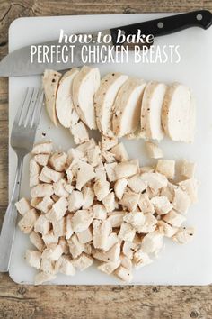 sliced chicken sitting on top of a cutting board with knife and fork next to it