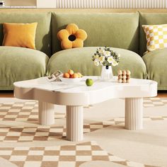 a white table sitting in front of a green couch on top of a checkered floor