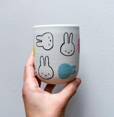 a hand holding a coffee cup with bunnies on it