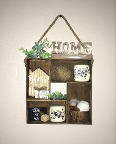 a wooden box with some items in it hanging on the wall next to a white wall