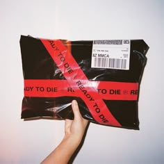 someone is holding up a bag with a red ribbon on it that says, hey to die ready to die