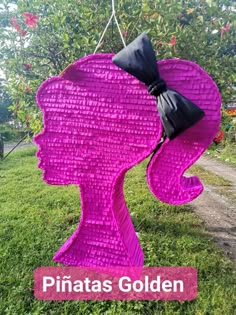 a pink sculpture with a bow on it's head and the words pinatas golden