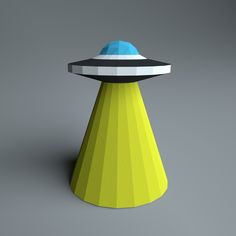 a yellow cone with a blue and black object on it's top sitting in front of a gray background