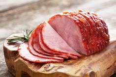 sliced ham sitting on top of a wooden cutting board