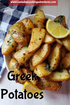 a white plate topped with potatoes and lemon wedges