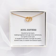 two gold interlocked rings on a necklace in a white box with the words soul sisters