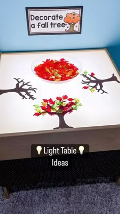 a light table with trees painted on it in front of a sign that reads decorate a fall tree