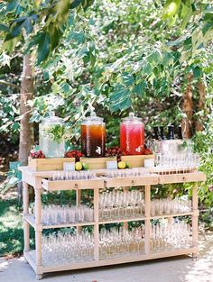 glasses and bottles are sitting on a table outside