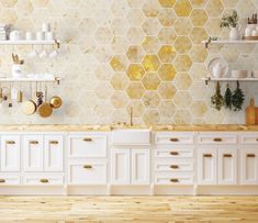 a kitchen with white cabinets and yellow hexagonal tiles on the wall behind it