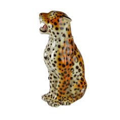 a ceramic figurine of a sitting leopard with its mouth open and tongue out