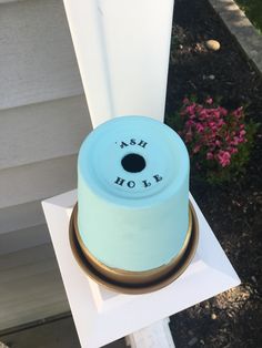 a small blue cake sitting on top of a white table next to a pink flower