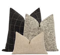 three pillows in different colors and patterns on a white background, each with a black checkerboard pattern