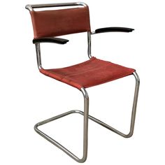 a red leather chair with metal frame and arm rests on a white background, it appears to be empty