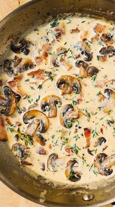 a pan filled with mushrooms and cheese on top of a wooden table