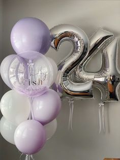 some balloons are hanging on the wall with the number twenty five in front of them