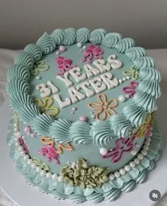 a birthday cake that is decorated with flowers and words on it's side, sitting on a table