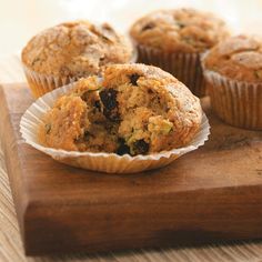 several muffins sitting on top of a wooden cutting board