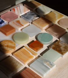 several different types of soaps are arranged on a counter top with various colors and shapes