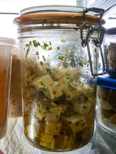 a jar filled with food sitting on top of a table next to another container full of food