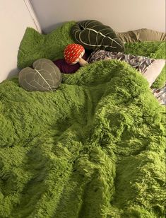 there is a green bed with two pillows and a stuffed turtle on top of it