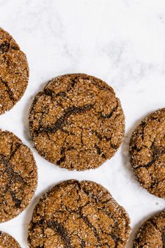 six cookies are arranged on a white surface with chocolate crumbs in the middle