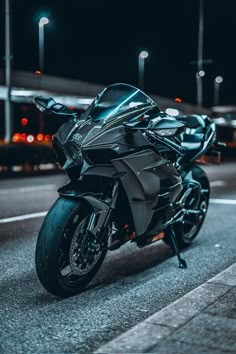 the motorcycle is parked on the side of the road at night time and it's shiny