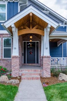 the front entrance to a house with blue siding and white trim