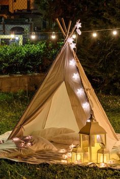 a teepee with lights on it sitting in the grass