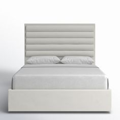 a bed with white sheets and pillows on it's headboard, in front of a wall