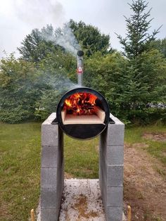 an outdoor fire pit in the middle of a field