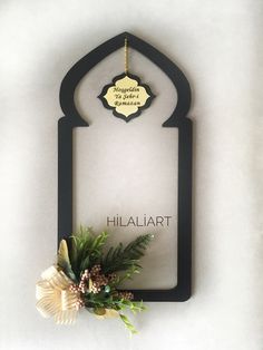 a white wall with a black frame and a flower on it that says hiallart