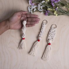 three crocheted keychains are being held by a person's hand