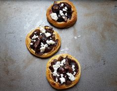 three pastries sitting on top of a pan covered in chocolate and white toppings