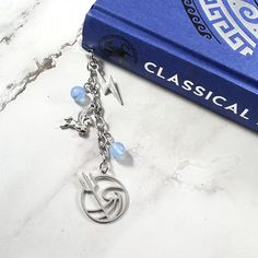 a book with a key chain attached to it sitting next to a pair of scissors