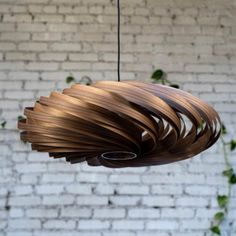 a wooden light fixture hanging from a brick wall