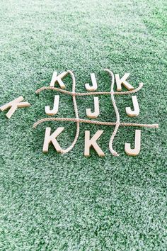 the letters are made out of wood and rope on the ground with grass in the background