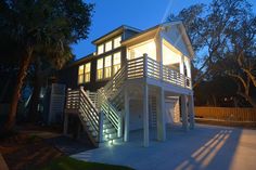 a house that is lit up at night with stairs leading to the upper floor and second story