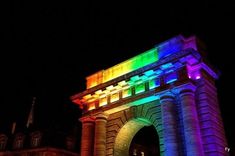 an arch lit up with rainbow lights at night