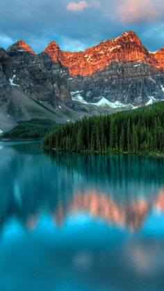 the mountains are reflected in the blue water