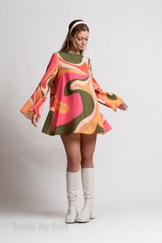 Step into the enchanting world of 70s Dress Style with our Bell Sleeve Dress, a captivating piece that encapsulates the spirit of the groovy era. This 60s 70s mini dress is a Boho Dress with a distinctive Bohemian touch, perfect for those seeking a Hippie Dress that exudes both charm and style. The Multicolor Tent Dress features a groovy pattern print inspired by the psychedelic aesthetics of the 70s, creating a visually striking and unique look. This slip-on dress is designed for ease and comfort, complemented by bell sleeves that add a touch of vintage flair. The single button enclosure behind the neckline enhances the Bohemian feel of the dress. Crafted from chiffon and fully lined material, this Groovy 70s Style Dress ensures a luxurious feel and graceful movement. The 100% polyester c Rich 60s Fashion, 1970s Formal Fashion, 70s Dinner Party Fashion, Groovy Glam Outfit, 70s Flare Sleeve Dress, Bell Sleeve Dress 70s, Vintage Orange Dress, Bohemian A-line Mini Dress For Party, Multicolor Mini Length Hippie Dress