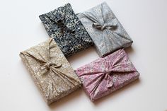 four wrapped gift boxes with bows on them