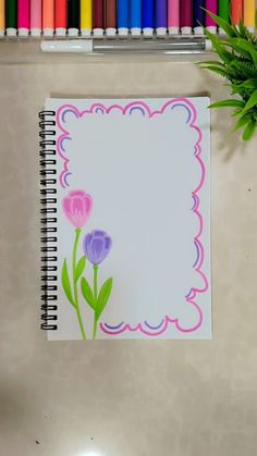 a notepad with flowers on it next to crayons