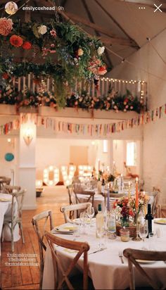 an image of a restaurant setting with flowers hanging from the ceiling and candles on the tables